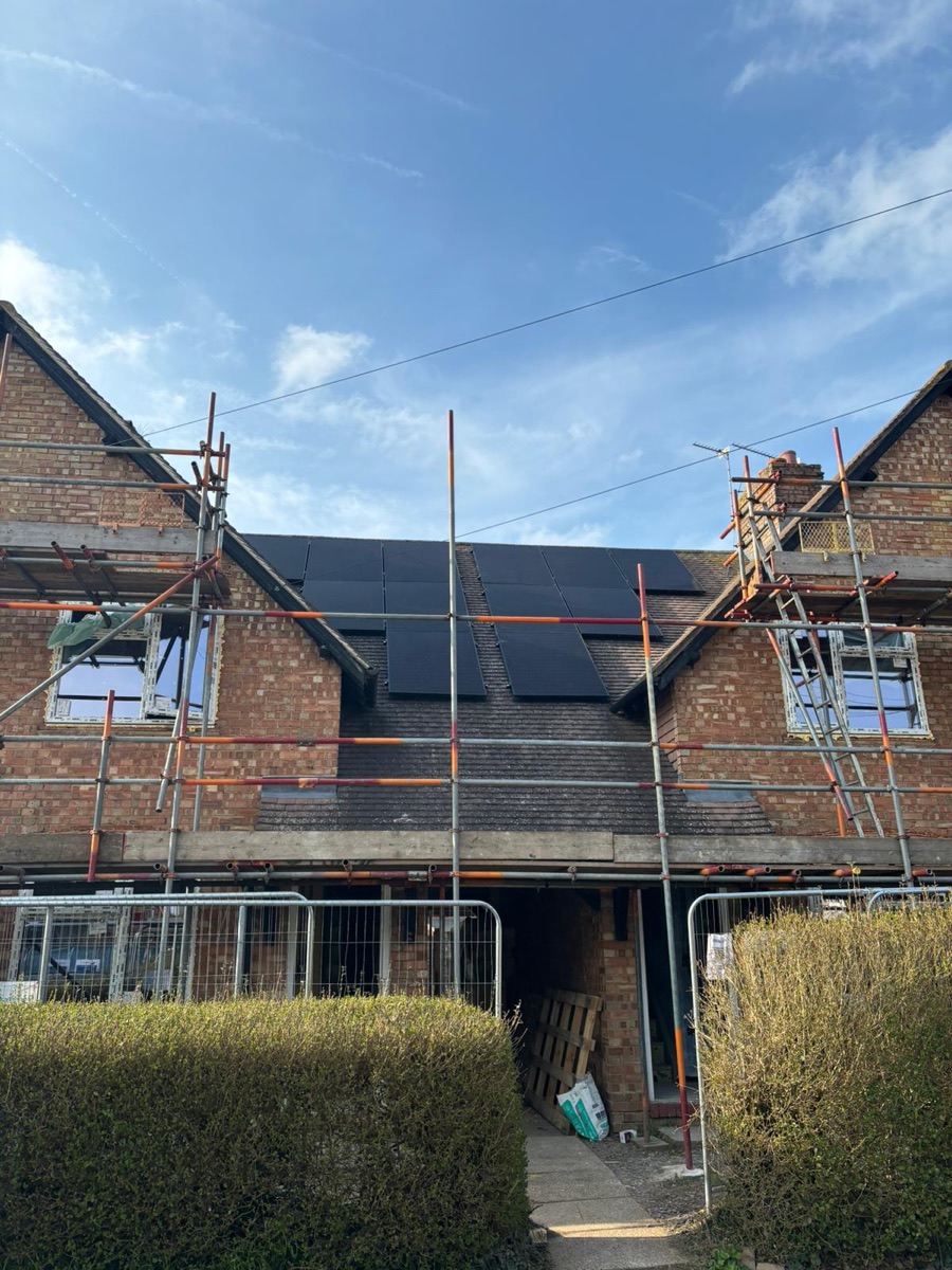 Scaffolding around a brick terrace with solar panels on the roof